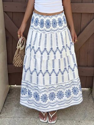 Bohemian maxi skirt with blue floral embroidery and tiered ruffles.