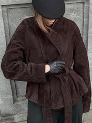 Dark brown suede tie-waist bolero jacket with a vintage-inspired cut, worn by a model with black gloves.