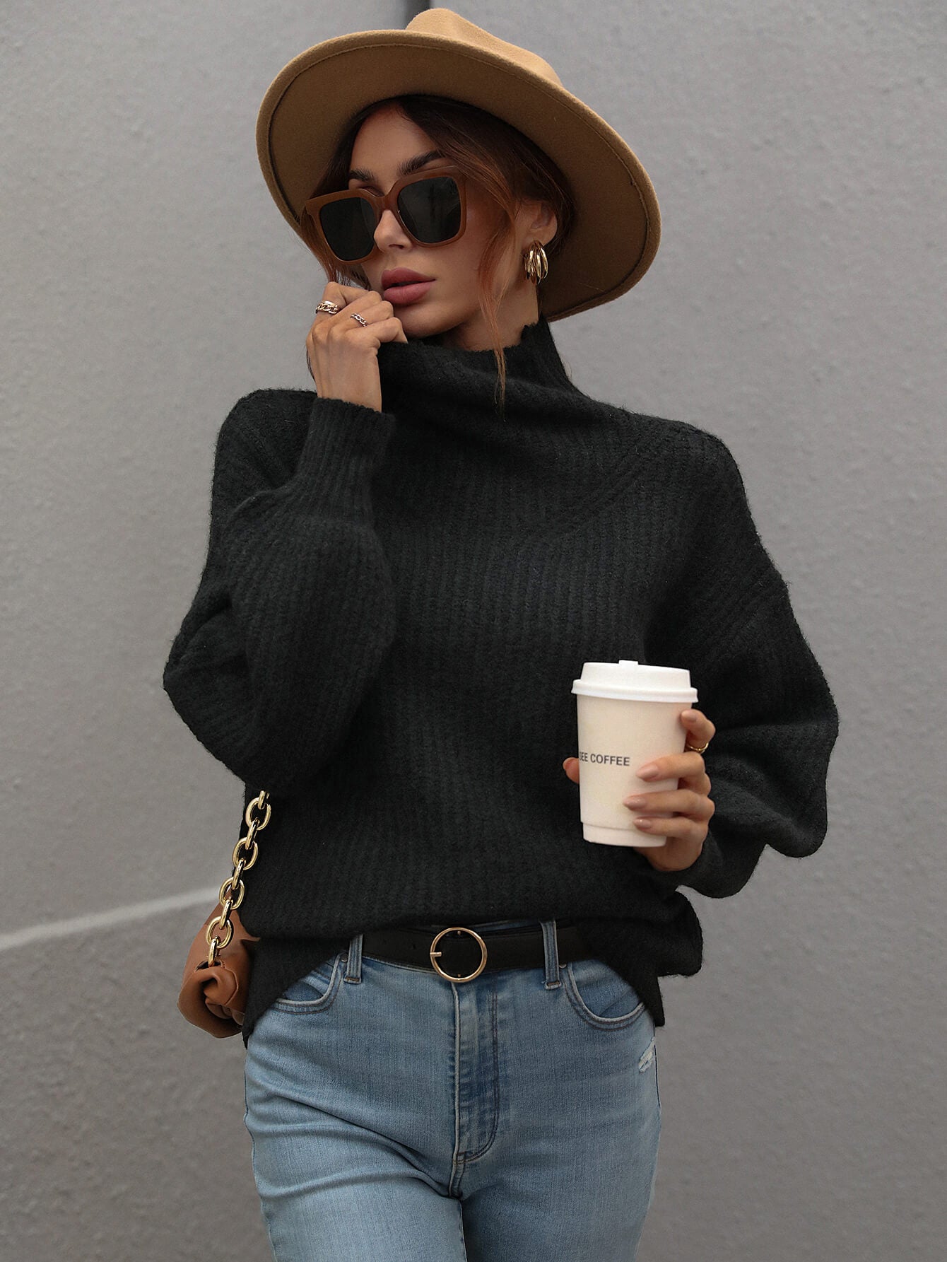 Black ribbed knit turtleneck sweater with voluminous sleeves and a relaxed fit.