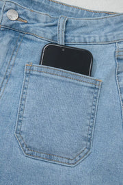 Light wash denim shorts with patch pocket detail, showing a smartphone.