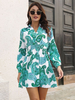 Teal paisley print shirred waist mini dress with long sleeves and a collared neckline.