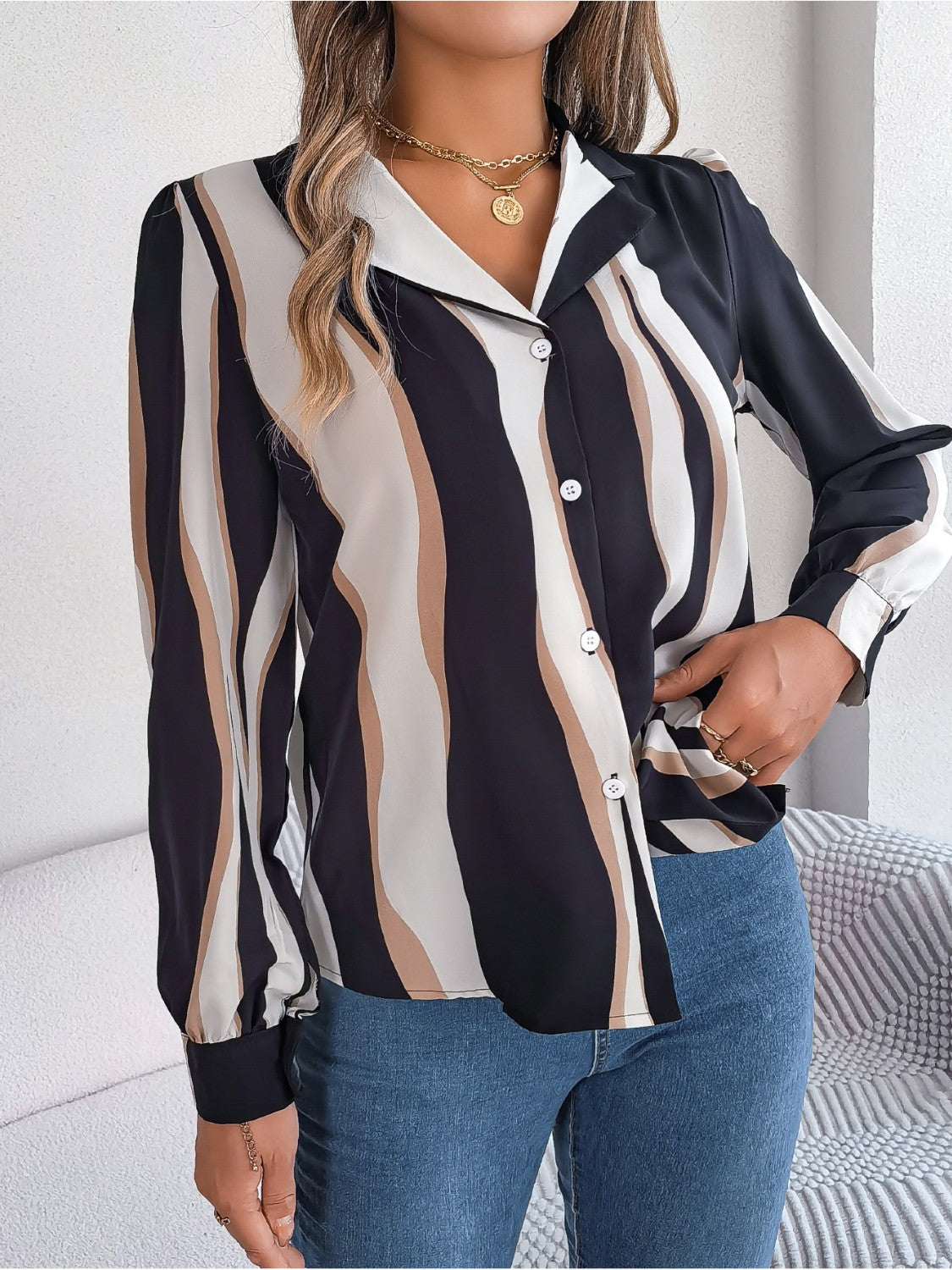 Collared blouse with wavy stripe pattern in black, tan, and cream, featuring a button-up front.