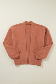 Open-front cropped knit cardigan in burnt coral with ribbed cuffs and hem.