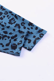 Sky blue leopard print performance leggings with black spots and visible stitching detail.