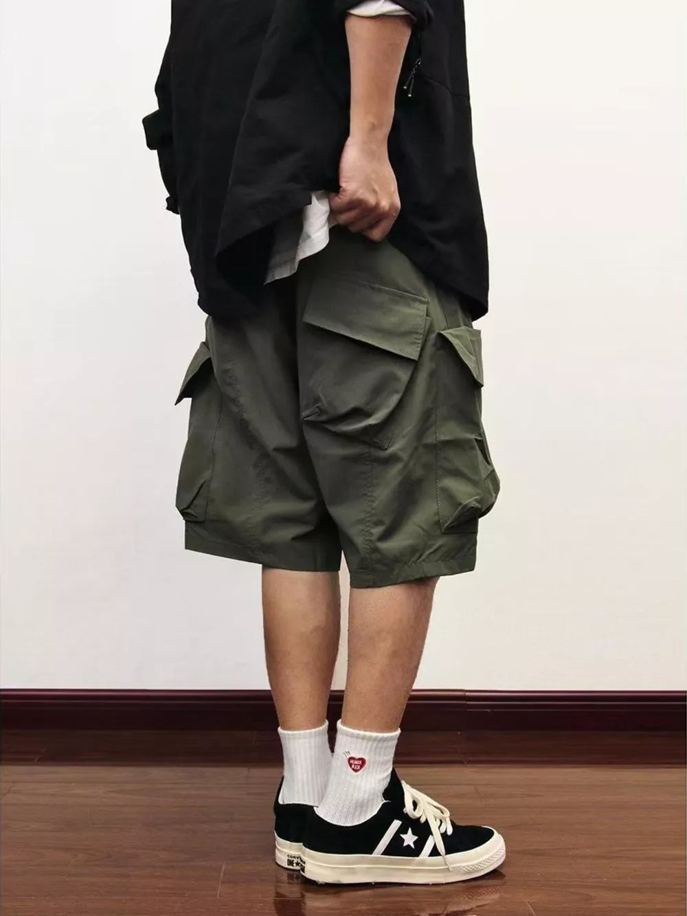 Relaxed fit green cargo shorts with multiple flap pockets.