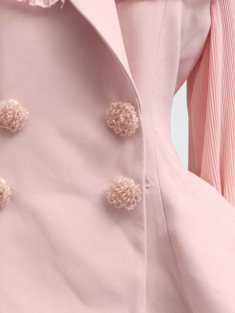 Pink skirt suit with frill collar, balloon sleeves, and beaded button details.