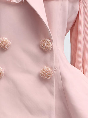 Pink skirt suit with frill collar, balloon sleeves, and beaded button details.