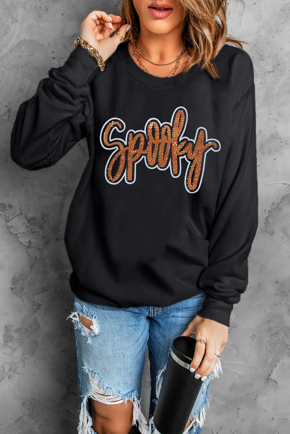 Black crewneck sweatshirt with sequined "Spooky" graphic and crew neckline.