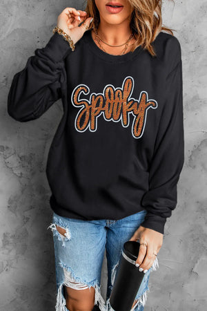 Black crewneck sweatshirt with sequined "Spooky" graphic and crew neckline.