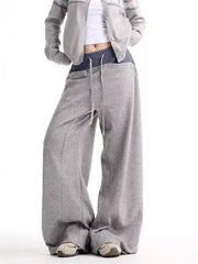 Grey wide-leg sweatpants with drawstring and pockets, styled with a cropped cardigan.