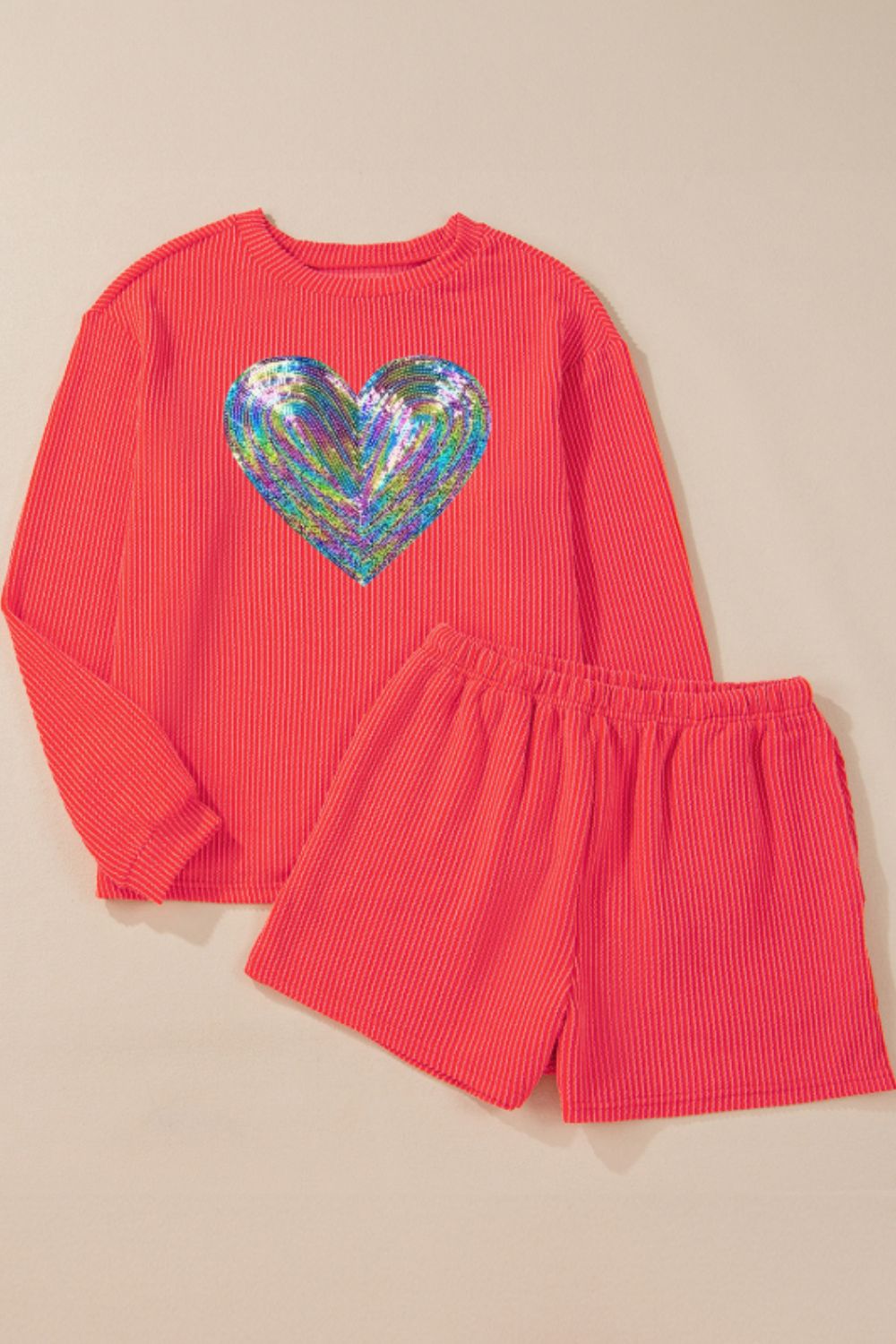 Orange-red ribbed lounge set with sequin heart detail on top.