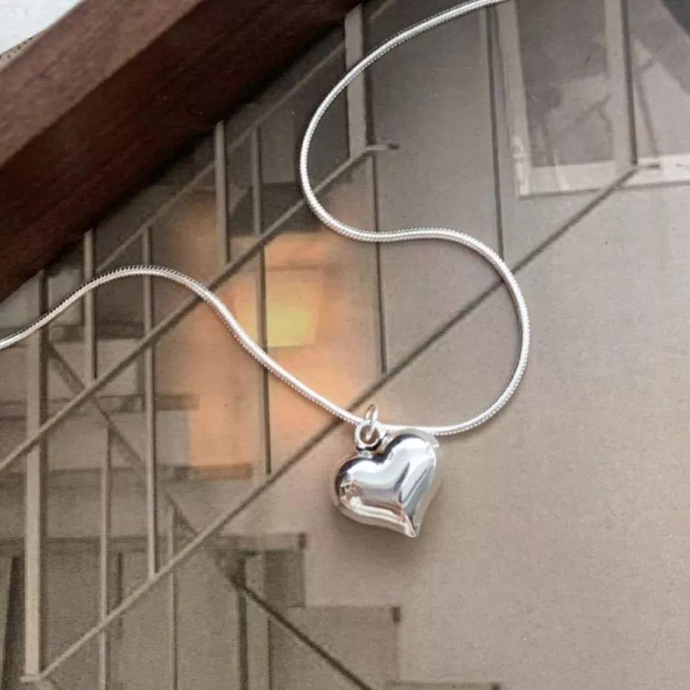 Sleek sterling silver heart pendant necklace with a snake chain.