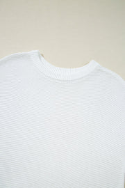 White boxy knit crop top with crew neck and ribbed trim.