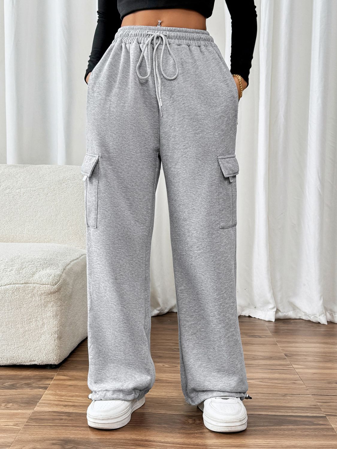 Light gray wide-leg sweatpants with cargo pockets and adjustable drawstring waist.