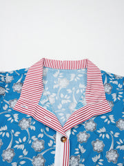 Blue floral cotton blouse with red and white striped collar and button detail.