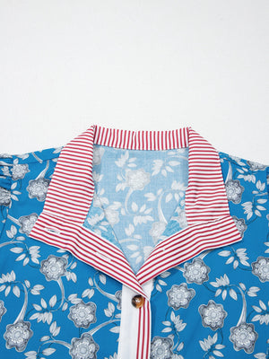 Blue floral cotton blouse with red and white striped collar and button detail.
