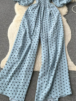 Light Blue polka dot smocked wide-leg romper with puff sleeves.