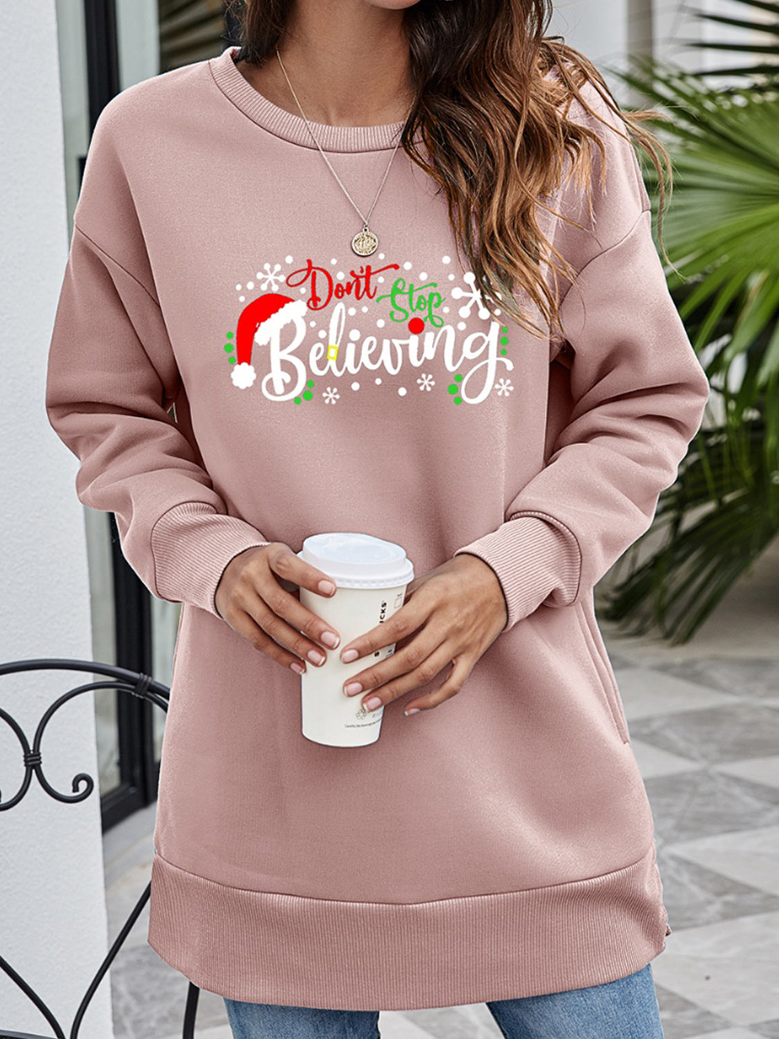 Dusty Pink graphic tunic sweatshirt with "Don't Stop Believing" holiday print, crewneck, long sleeves, and pockets.
