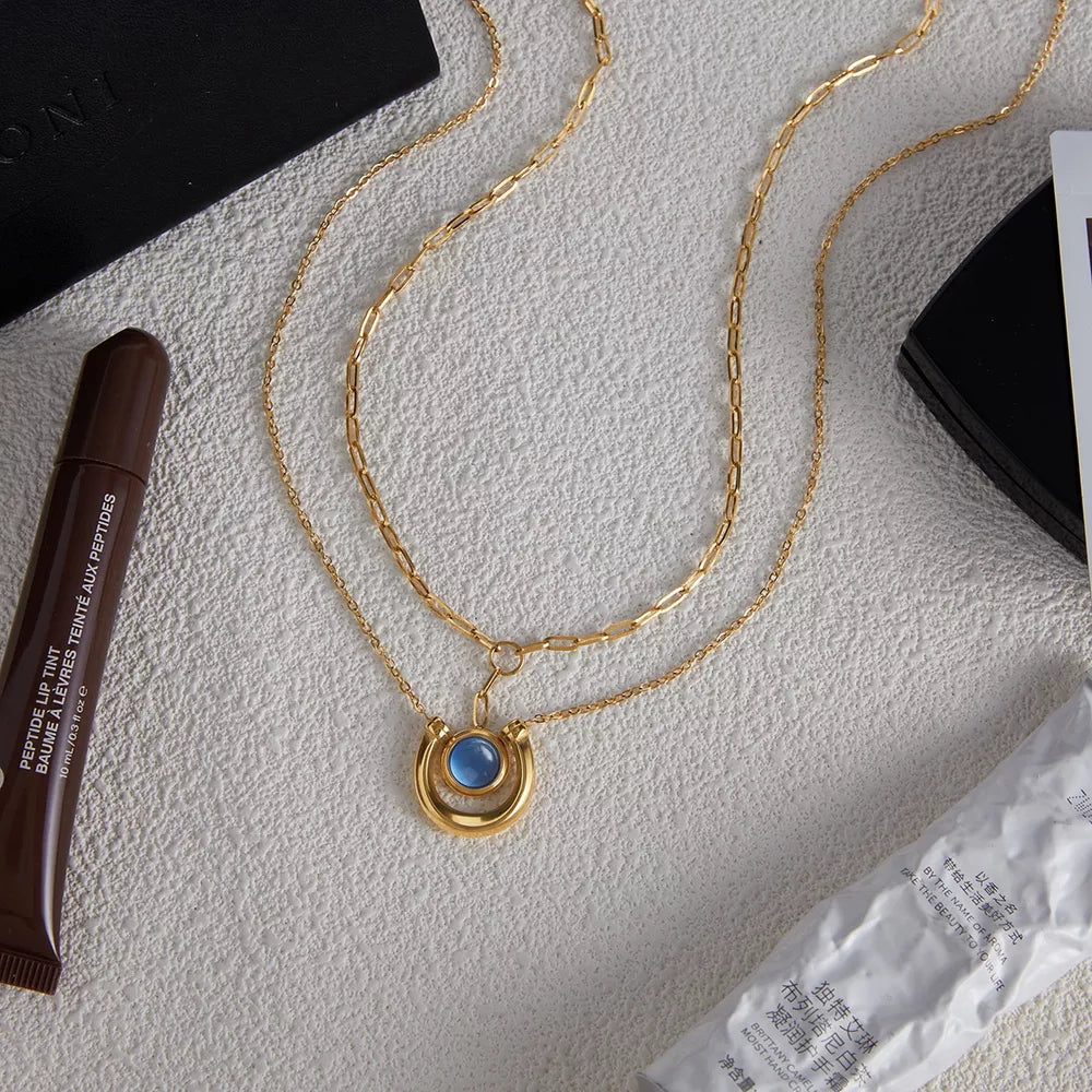 Elegant gold-plated layered necklace with a blue stone pendant.