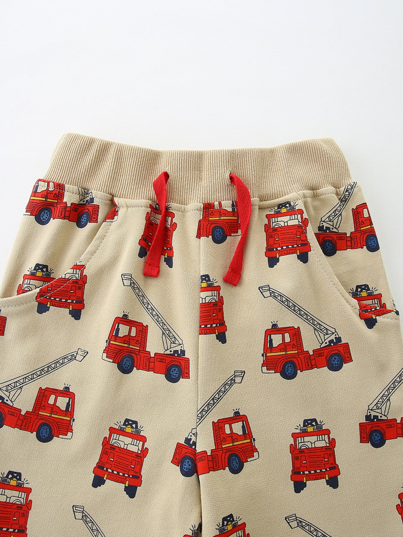 Boys' beige cotton underwear with allover red firetruck print and red drawstring.