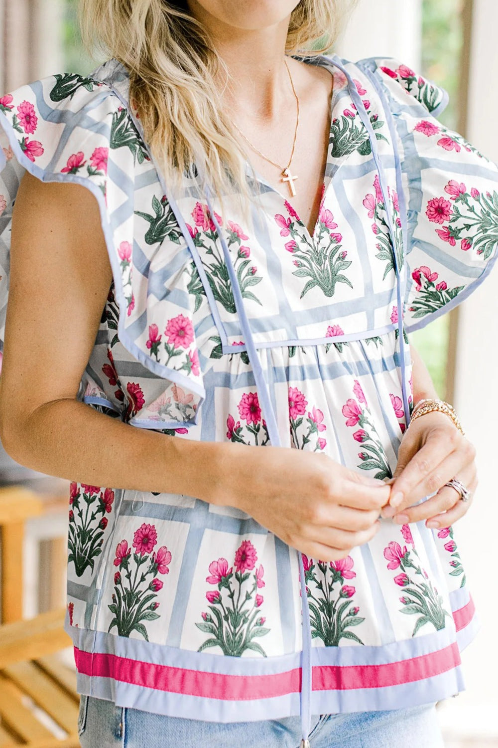 Women's ruffle sleeve blouse with floral print, blue stripes, and tie neck