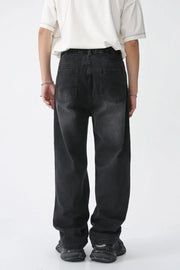 Distressed wide-leg denim jeans in dark wash with raw edge hem and classic back pockets.