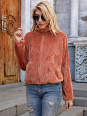 Textured corduroy zip-up jacket in terracotta with pockets and a high collar.