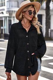 Black waffle-knit oversized shirt jacket with button-down front and chest pocket.