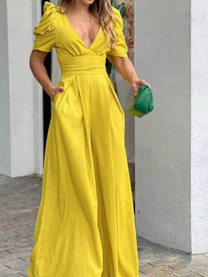 Canary yellow romper with puff sleeves, deep V-neck, cinched waist, and pockets.