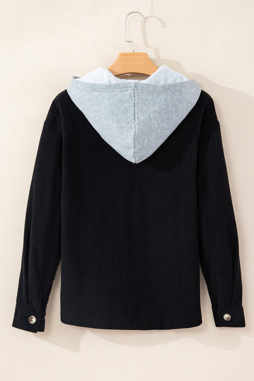 Black corduroy shirt jacket with contrast light gray hood and button cuffs.