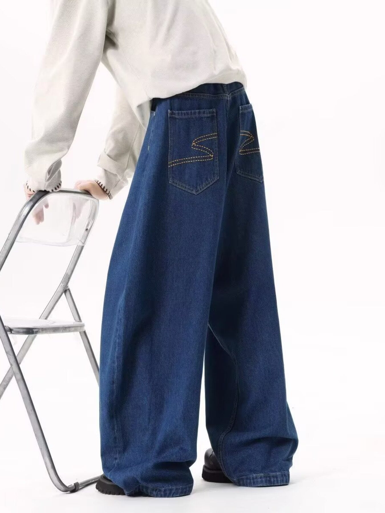 Men's dark blue wide leg jeans with contrast stitching and embroidered back pockets.