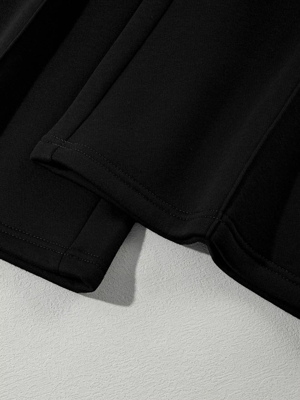 Black cotton joggers with visible stitching detail on the hem.