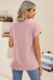 Blush pink eyelet v-neck top with short sleeves and a casual fit.