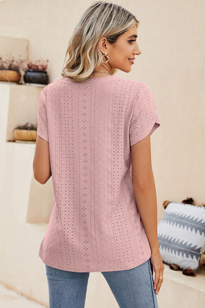 Blush pink eyelet v-neck top with short sleeves and a casual fit.