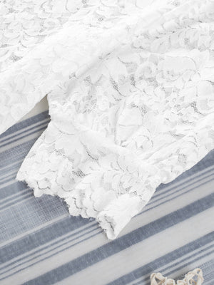 White lace short sleeve blouse with floral pattern and scalloped hem detail.