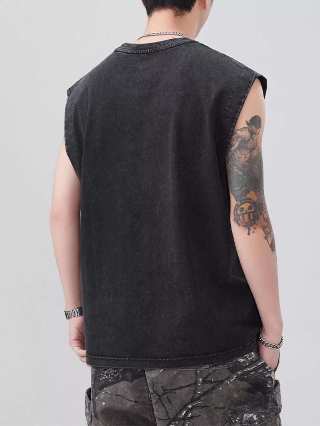 Black oversized cotton round-neck tank top with raw armholes, worn by a man.