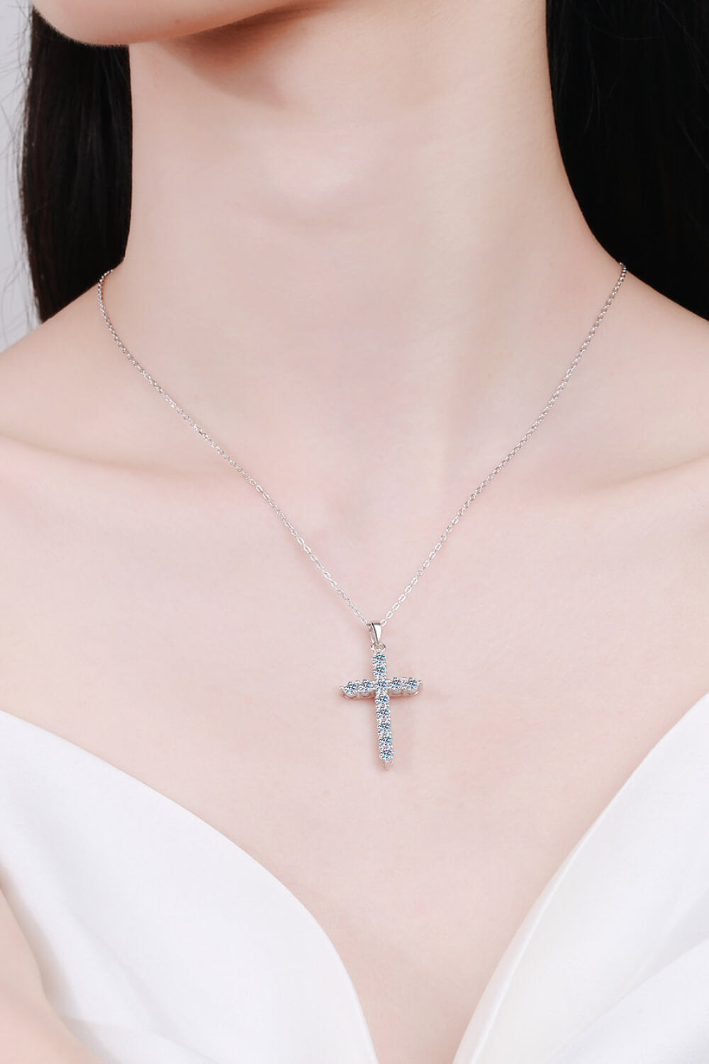 Silver pavé cross necklace with clear stones on a delicate chain.