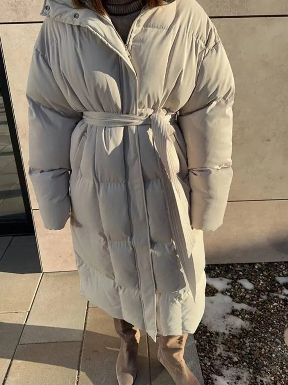 Ivory white padded trench coat with tie belt and hood, long sleeves, full length.