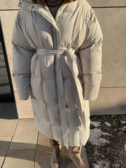 Ivory white padded trench coat with tie belt and hood, long sleeves, full length.