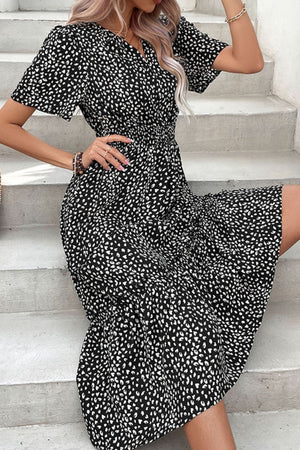 Black smocked waist midi dress with flutter sleeves and a dalmatian-like print.