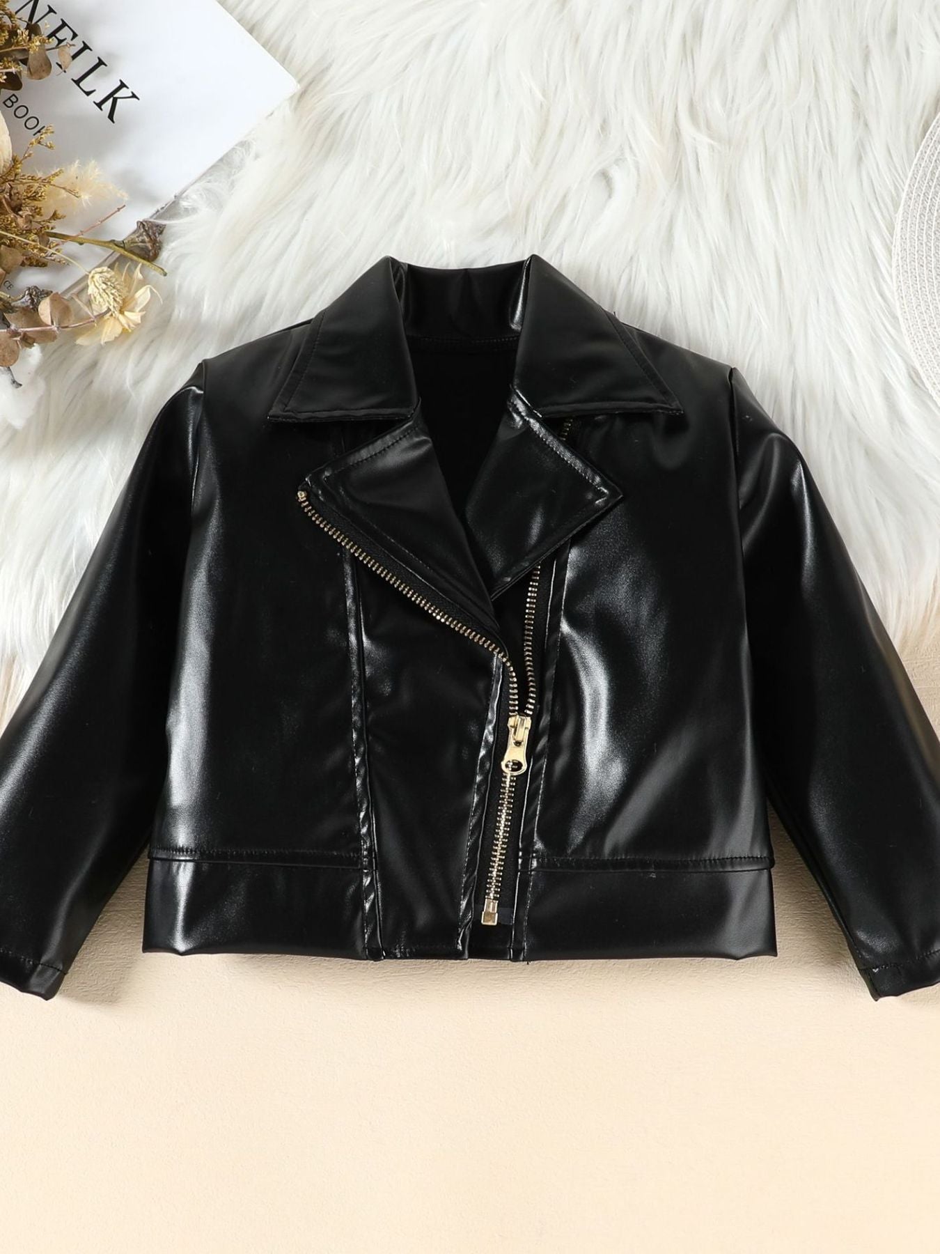 Black faux leather baby jacket with asymmetrical zipper and lapel collar.