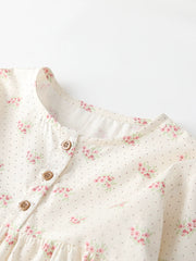 Cream cotton toddler dress with pink floral and dot print, button front detail.