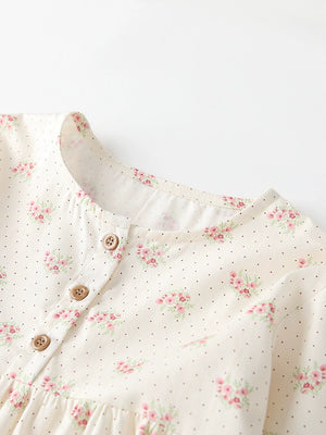 Cream cotton toddler dress with pink floral and dot print, button front detail.