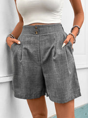 Gray high-waisted linen shorts with pleats and button closure.
