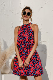 Halter neckline floral mini dress in navy with red and blue blossoms, featuring a gathered bodice and elastic waist.