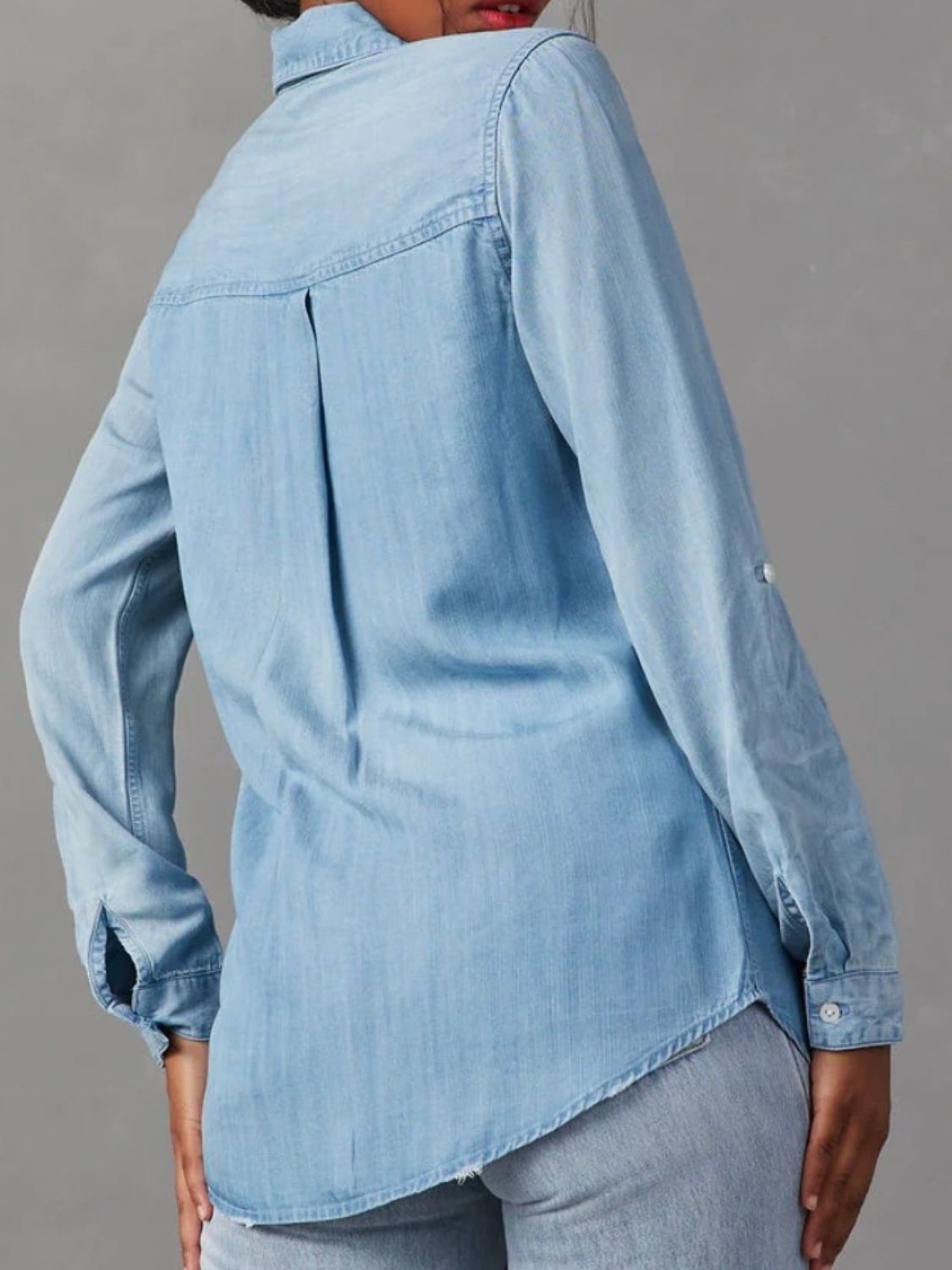 Light blue washed denim utility shirt with buttoned cuffs and back pleat detail.