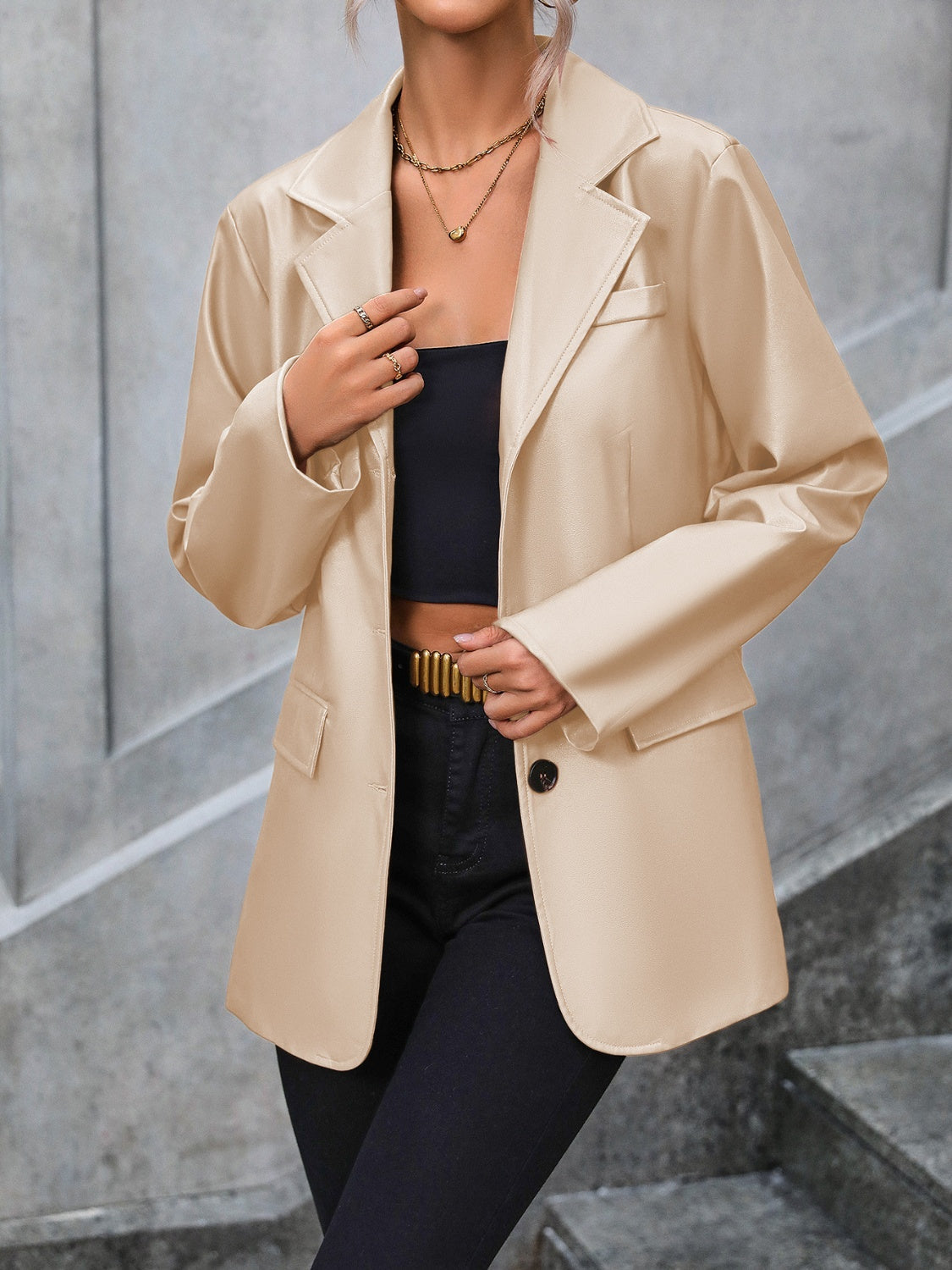 Tan faux leather tailored blazer with buttoned front and flap pockets.