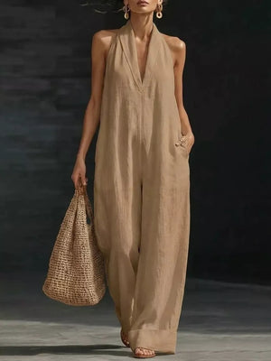 Camel halter neck wide-leg jumpsuit with deep V-neck and pockets.
