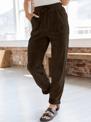 Chocolate corduroy tapered trousers with drawstring waist and pockets.