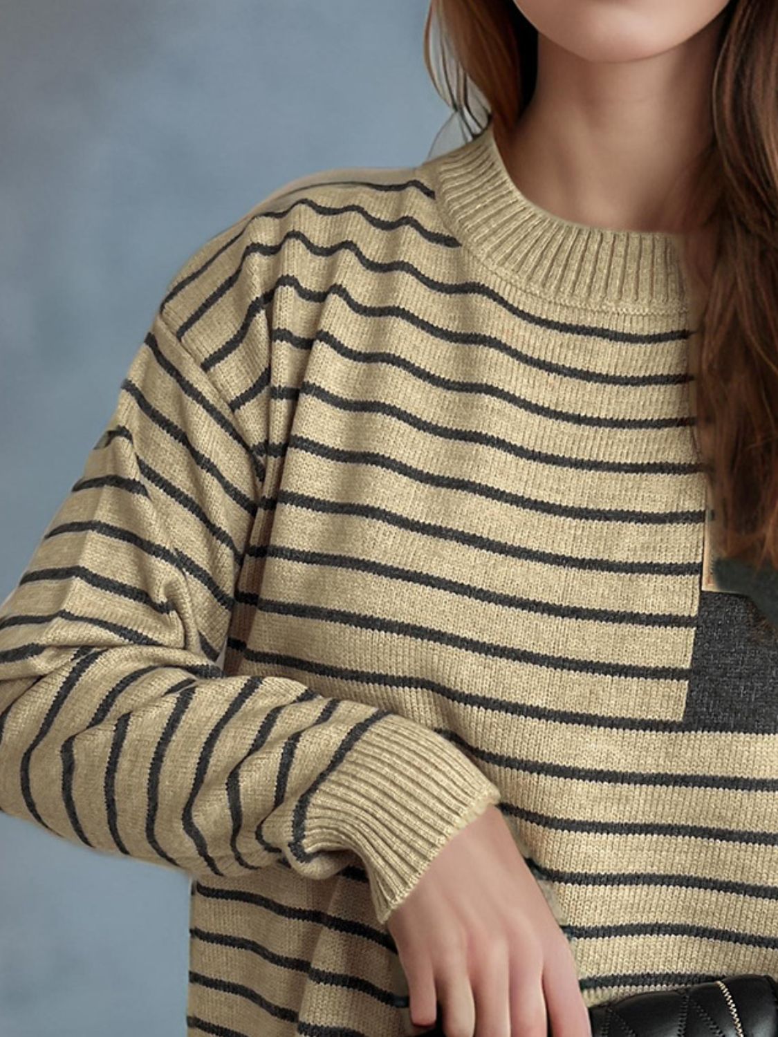 Tan and black striped knit sweater with asymmetrical pocket detail.